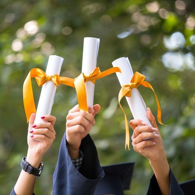 Imagem de três diplomas sendo erguidos. Os tecnólogos podem prestar concurso de nível superior.